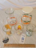 Overview of all five glass items: three character glasses front, two pitchers behind