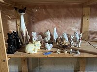 Full shelf view of cat figurine assortment
