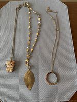 Three necklaces laid out showing overall design and pendants