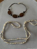 Both necklaces laid flat on mat