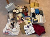 Overview of entire lot on floor with tote, fabrics, bags and tools