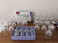 Group of boxed wine glasses, additional glasses displayed, and tumblers