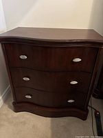 Front view of three-drawer dark wood dresser