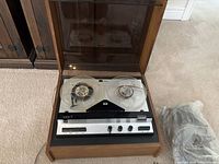 Front view of Dual reel-to-reel recorder with lid open showing both reels and control panel