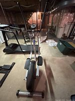 Full front view of elliptical trainer showing handlebars, pedals, and flywheel