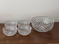 Five clear diamond-pattern glass bowls on table