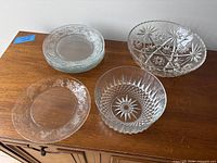 Full view of two serving bowls and stack of plates on cabinet