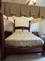 Full view of assembled four-poster king bed with mattress and canopy valances