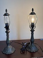 Front view of both matching metal lamps showing design and cords