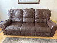 Full front view of three-seat brown leather sofa