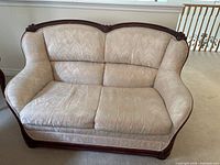 Front view of love seat showing upholstery and wood frame
