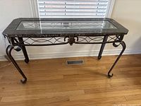 Full front view of console table showing marble border, glass inset, metal legs and apron