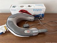 Neck massager with AC adapter alongside boxed Dolphin infrared massager