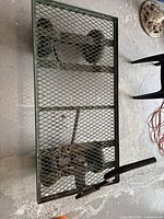 Top view of green metal mesh garden cart showing full platform and wheel arrangement