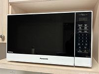 Front view of Panasonic microwave showing smoked glass door and control panel
