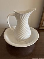 Pitcher resting inside matching bowl showing swirl pattern