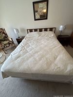 Full view of bed showing headboard, mattress and surrounding items