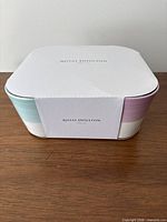 Closed box showing front sleeve with pastel mug edges