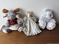 All three stuffed figures upright on surface