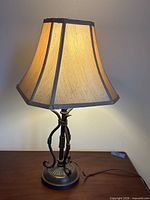 Full view of lit table lamp displaying shade and base