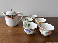 teapot and five cups grouped on tabletop