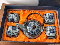 Boxed set showing teapot and four cups in satin-lined box