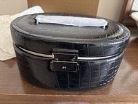 Closed black faux crocodile oval jewelry case with clasp and handle