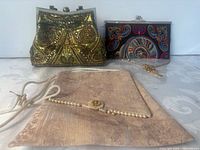 Front view of three evening bags showing designs and clasps