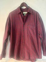 Front view of red/navy/white plaid Eddie Bauer flannel shirt on hanger
