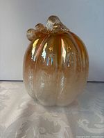 Front view of amber iridescent glass pumpkin