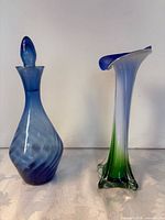 Trumpet vase and blue decanter side by side