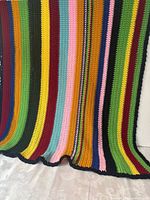 Full view of multicolor crocheted throw showing stripe pattern and edging