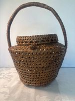 Front view of hand-woven wicker basket showing handle and lid