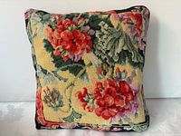 Needlepoint pillow with yellow ground and red flowers front view