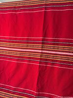 Full view showing red blanket with multicolour stripes