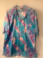 Front view of floral rayon Hawaiian camp shirt on hanger
