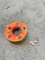 Top view of yellow/orange plastic reel with cord