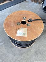 Wooden spool showing label Speaker Cable 16 AWG/430' outdoor with black cable wound