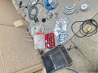 overview of assorted electrical supplies on concrete surface including boxes, cable, conduit, connectors