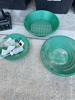 Two green pans, bag of accessories including grit packets and pellets