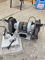 Overall view of Delta GR100 bench grinder with manual and accessories