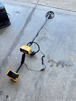 Full view of Garrett ACE 250 metal detector laid out on floor showing coil, shaft, control box, armrest and attached headphones