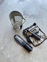 Metal sand scoop, camo fabric pouch with pinpointer holster, Garrett Pro-Pointer partially visible