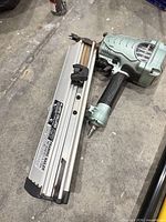 Full view of Hitachi NR90AE(S1) framing nailer showing housing, magazine, and installed air fitting