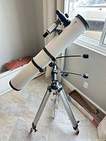 Side view of telescope on tripod showing optical tube, mount, finder and eyepiece