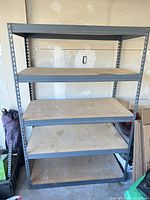 Full view of assembled gray metal shelving unit with five brown shelves