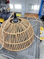 Small woven rattan pendant shade showing cord and socket