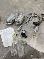 lot overview showing both spray guns, both metal cups, regulators, filter, wrench, manual, spare parts