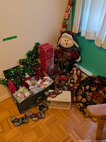 Corner grouping with plush snowman, slender figures, wreaths, garlands, mugs and candle holder box