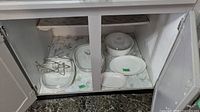 Entire lot inside cabinet showing dishes, lids, racks